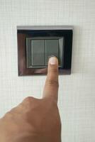 A finger turning on lighting switch . photo