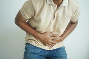 young man suffering stomach pain close up. photo