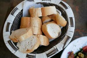 Wicker basket with bread on wooden table photo