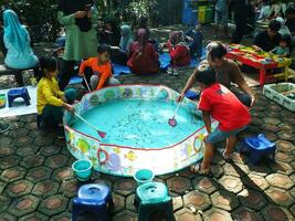 Bandung City, West Java, Indonesia. 19 October 2023. Bright mornings days on weekends, happy childhoods, playing in city parks. Family gathering making fun with children. photo