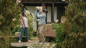 A multi-ethnic family is playing while moving into a new purchased house. African dad, Caucasian mom, son. video