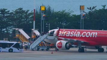 phuket, Tailandia febrero 27, 2023 pasajeros en el móvil escalera embarque el bajo costo aerolínea airasia a phuket internacional aeropuerto. embarque. pasajero avión. viaje concepto. video