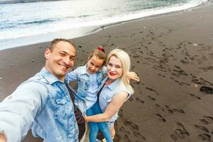 Happy family standing on the beach on the dawn time photo