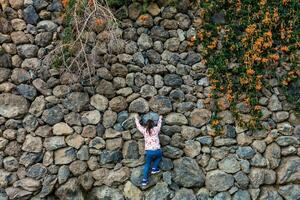 A young girl climbs over the rocks on top of a hill photo