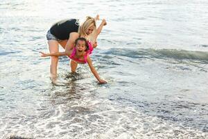 Family holiday on Tenerife, Spain. Mother with daughter outdoors on ocean. Portrait travel tourists - mom with daughter. Positive human emotions, active lifestyles. Happy young family on sea beach photo