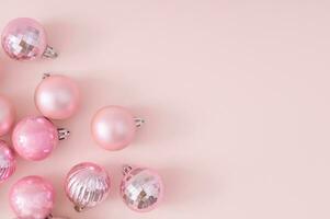Creative trendy layout made of pink Christmas baubles on pastel pink background. New Year party background. Minimal style. Christmas or New Year concept. Winter holidays celebration idea. Flat lay. photo