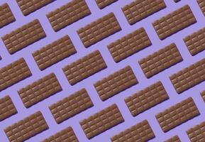 creativo de moda modelo hecho con delicioso chocolates en ligero púrpura antecedentes. mínimo concepto. sabroso chocolate barras composición. sabroso dulce comida idea. chocolate estético modelo antecedentes. foto