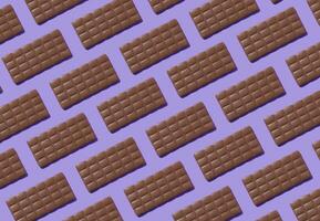Creative trendy pattern made with delicious chocolates on light purple background. Minimal concept. Yummy chocolate bars composition. Tasty sweet food idea. Chocolate aesthetic pattern background. photo