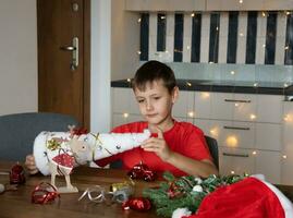 cute Boy makes Christmas crafts by himself. New Year. Handmade work. DIY photo