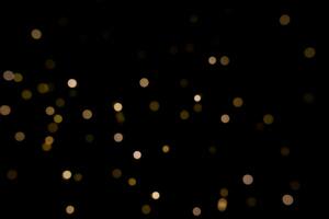 Black background with bokeh golden light effects for christmas time. Photo