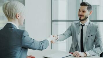 HR male manager shaking hand to female candidate after having job interview in modern office indoors photo