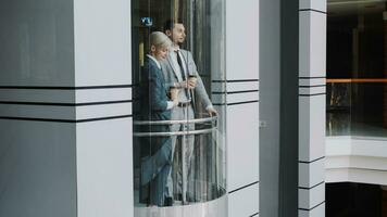 businesswoman and businessman colleagues talking in moving elevator in modern business center indoors photo