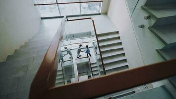 parte superior ver de dos empresarios reunirse a escalera en moderno oficina centrar y hablando mientras teniendo descanso hora foto