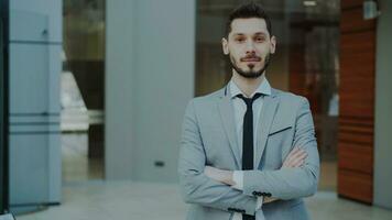 Portrait of successful young smiling businessman looking into camera in modern office indoors photo