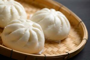 Chinese food, Baozi is a traditional delicacy in China, Bread Food Photography So Tempting, Delicious baozi, Chinese steamed meat bun is ready to eat on serving plate and steamer photo