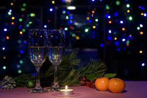 Two glasses of wine on the table. Christmas New Year lights and decorations. photo