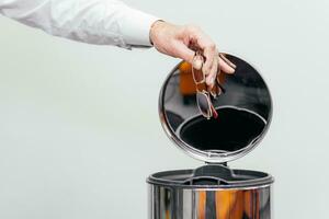 Man throwing glasses into trash container. A happy man with good vision. Ophthalmic problems, poor vision in old age, macular degeneration. Vision correction and treatment. photo