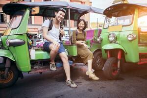 couples of young traveling people sitting on tuk tuk bangkok thailand photo