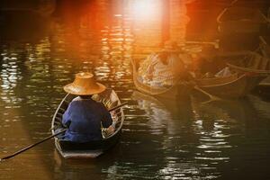 woman sailing thai trading boat in floating maket most popular traveling destination in dumnern sadauk canal ratchaburi thailand photo