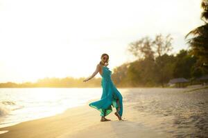 beautiful asian younger woman wearing  green dress relaxing on summer vacaiton beach photo