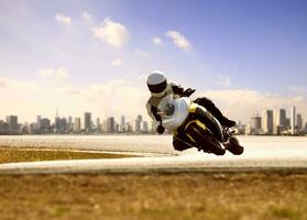 hombre vistiendo la seguridad traje montando deporte carreras motocicleta en agudo curva autopista foto