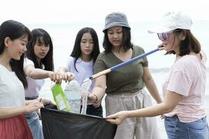 group of volunteers cleaning sea beach photo