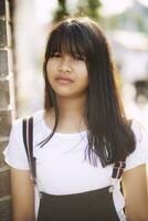 retrato de asiático adolescente en pie al aire libre con ojo contacto a cámara foto
