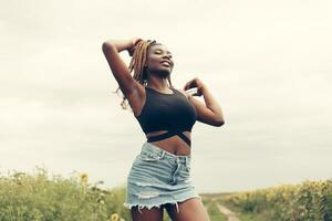 African American girl in a field of yellow flowers at sunset photo