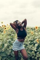 African American girl in a field of yellow flowers at sunset photo