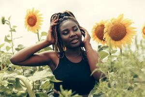 African American girl in a field of yellow flowers at sunset photo