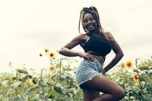 African American girl in a field of yellow flowers at sunset photo