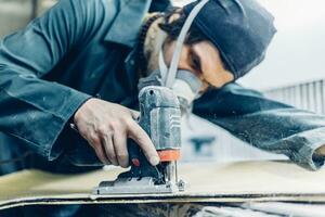 A carpenter cuts a board with an electric jigsaw. photo