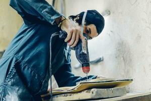 A carpenter cuts a board with an electric jigsaw. photo