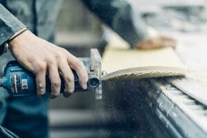 A carpenter cuts a board with an electric jigsaw. photo