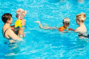 dos mujer y su niños en el piscina foto