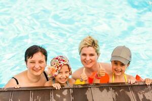 dos mujer y su niños en el piscina foto