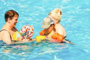 dos mujer y su niños en el piscina foto