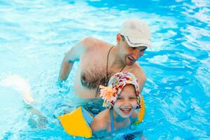 Father playing with his daughter in swimming pool photo