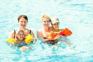 two women and their children in the pool photo