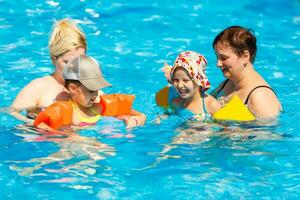 two women and their children in the pool photo