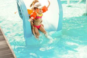 Cute toddler girl playing in swimming pool photo