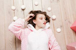 Cute little girl in pajama with sweets sitting on the floor photo