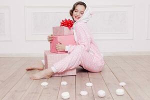 Cute little girl in pajama with sweets sitting on the floor photo