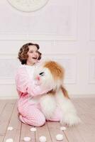 Cute little girl in pajama with sweets sitting on the floor photo