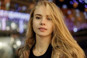 woman smiling in the night against evening lights bokeh photo