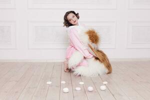 Cute little girl in pajama with sweets sitting on the floor photo