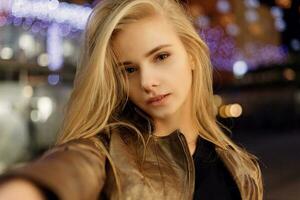 woman smiling in the night against evening lights bokeh photo