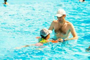 Father playing with his daughter in swimming pool photo