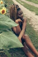 africano americano niña en un campo de amarillo flores a puesta de sol foto