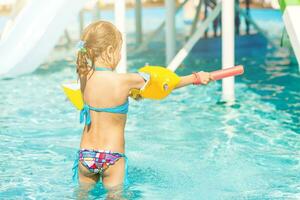 Cute toddler girl playing in swimming pool photo